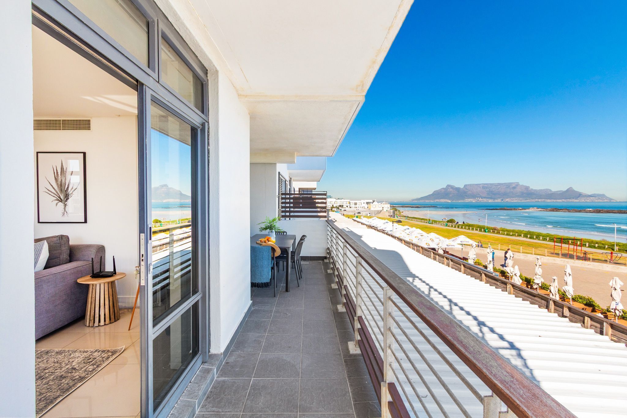 Een balkon met uitzicht op het strand en de bergen.