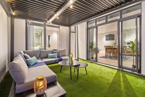 A modern living room with a sectional sofa, a round coffee table, and a floor lamp. - Eden On The Bay 102 (Cape Town)