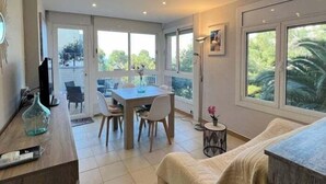 Amplia sala de estar con mesa de comedor, sillas, sofá y una mesita auxiliar.