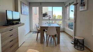 Una cocina moderna con comedor, ventanas amplias y televisor de pantalla plana.