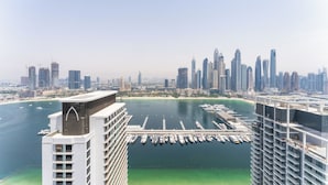 A high-rise hotel with a marina and city skyline in the background.
