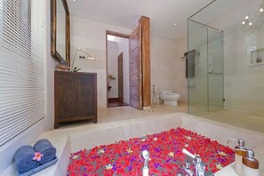 Deluxe suite | Badkamer | Een aparte badkuip en douche, handdoeken, zeep, shampoo