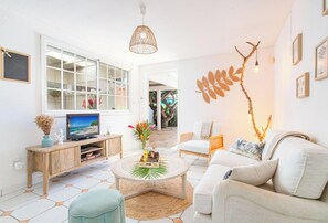Un salon moderne comprenant un téléviseur, un canapé, une table basse et des éléments décoratifs.