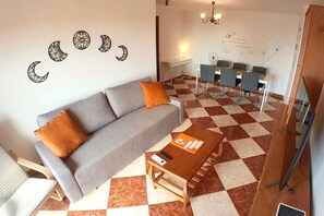 Uma sala moderna com sofá, mesa de centro e mesa de jantar com cadeiras.
