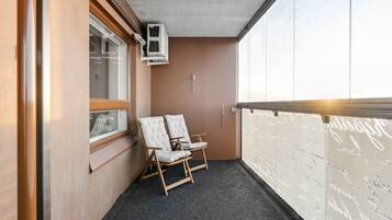 A room with two white cushioned chairs, a window, and a wall with writing.