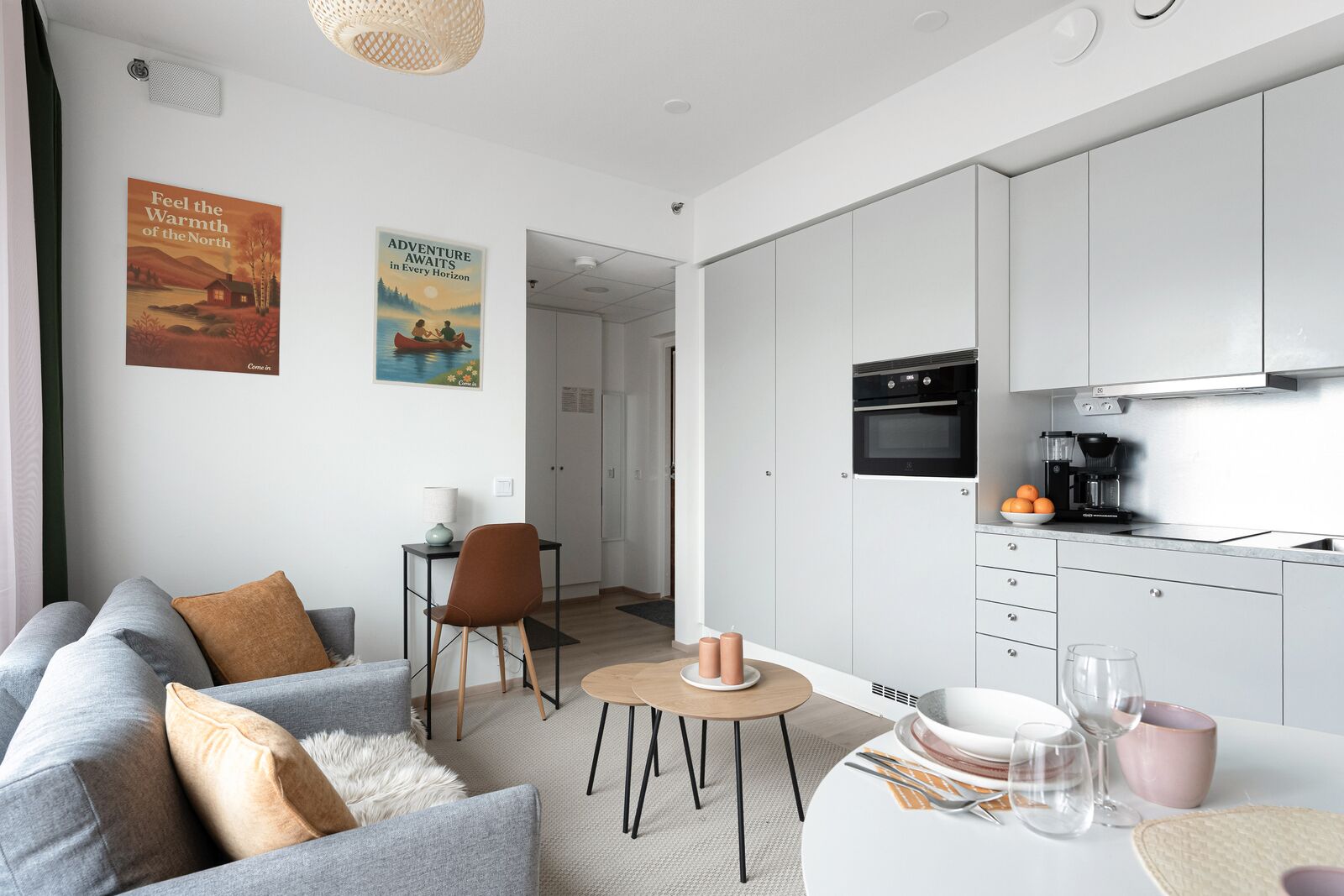 A modern apartment with a living area, a dining table, a kitchen, and a view of the outside.