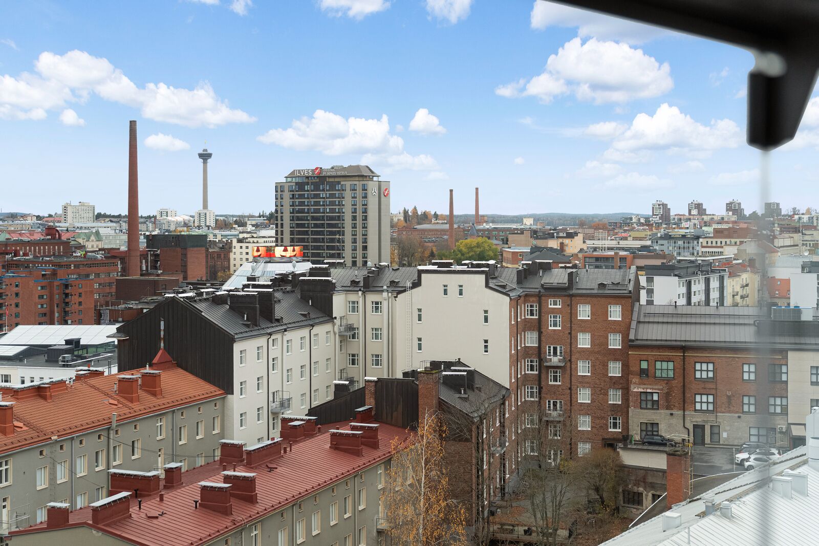 A cityscape with a mix of residential and commercial buildings, including a prominent hotel with a sign.