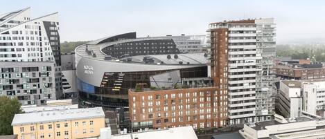 A modern stadium with a curved roof and multiple levels, surrounded by urban buildings.