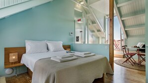 Een slaapkamer met een groot bed, een nachtkastje, een lamp en een raam.