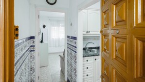 A kitchen with white cabinets, a sink, and patterned tiles. - Apartment 'Flat Near Macarena Basilica' with Wi-Fi and Air Conditioning (Seville)