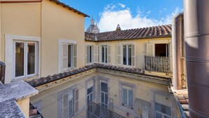 A courtyard with a tiled roof, a building with a dome, and a metal structure.