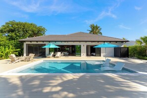 A modern house with a swimming pool, outdoor seating, and a covered patio. - SERENITY ON SUNRISE~Canal Front 5 BR/5.5 Ba New Town Home w/ Pool & Dockage! (Key West)