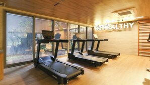A gym with treadmills, a wall-mounted control panel, and a large window with a view of the outdoors. - ON Brooklin (Sao Paulo)