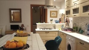 Une cuisine équipée d’une table à manger, d’un lave-linge et de placards.