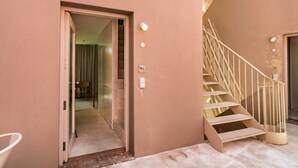 Un interno moderno con una scala, una porta che dà su un'altra stanza e un interruttore a muro.