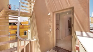 Ein mehrgeschossiges Interieur mit einer Treppe, einer Tür zu einem Raum und einem sichtbaren Feuerlöscher.