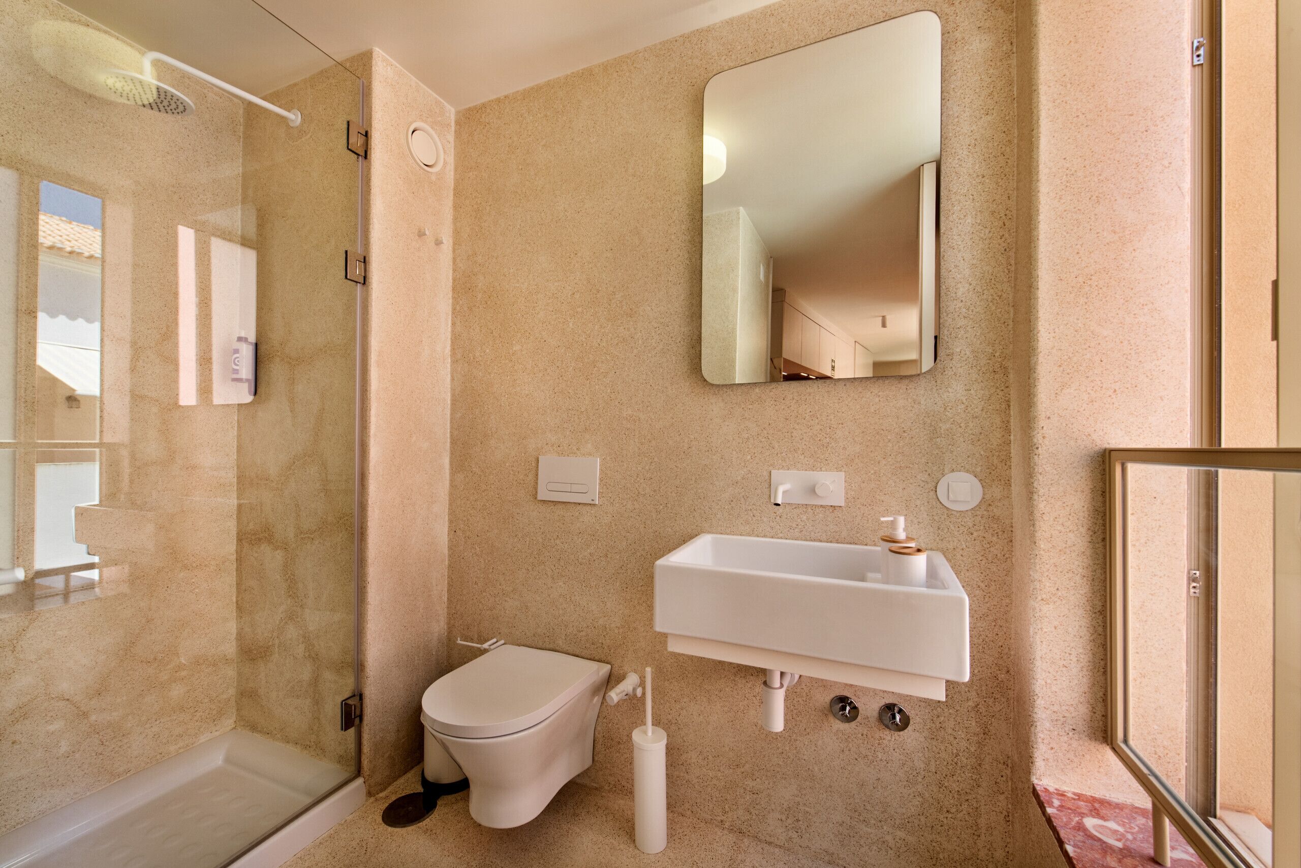 A modern bathroom with a shower, toilet, sink, and a large mirror.