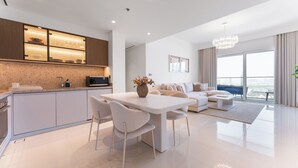 Un espace de vie moderne comprenant une cuisine, un coin repas et une grande fenêtre donnant sur la ville.