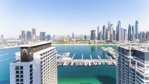 Un hôtel de grande hauteur doté de nombreux balcons donnant sur une marina où sont amarrés des bateaux.
