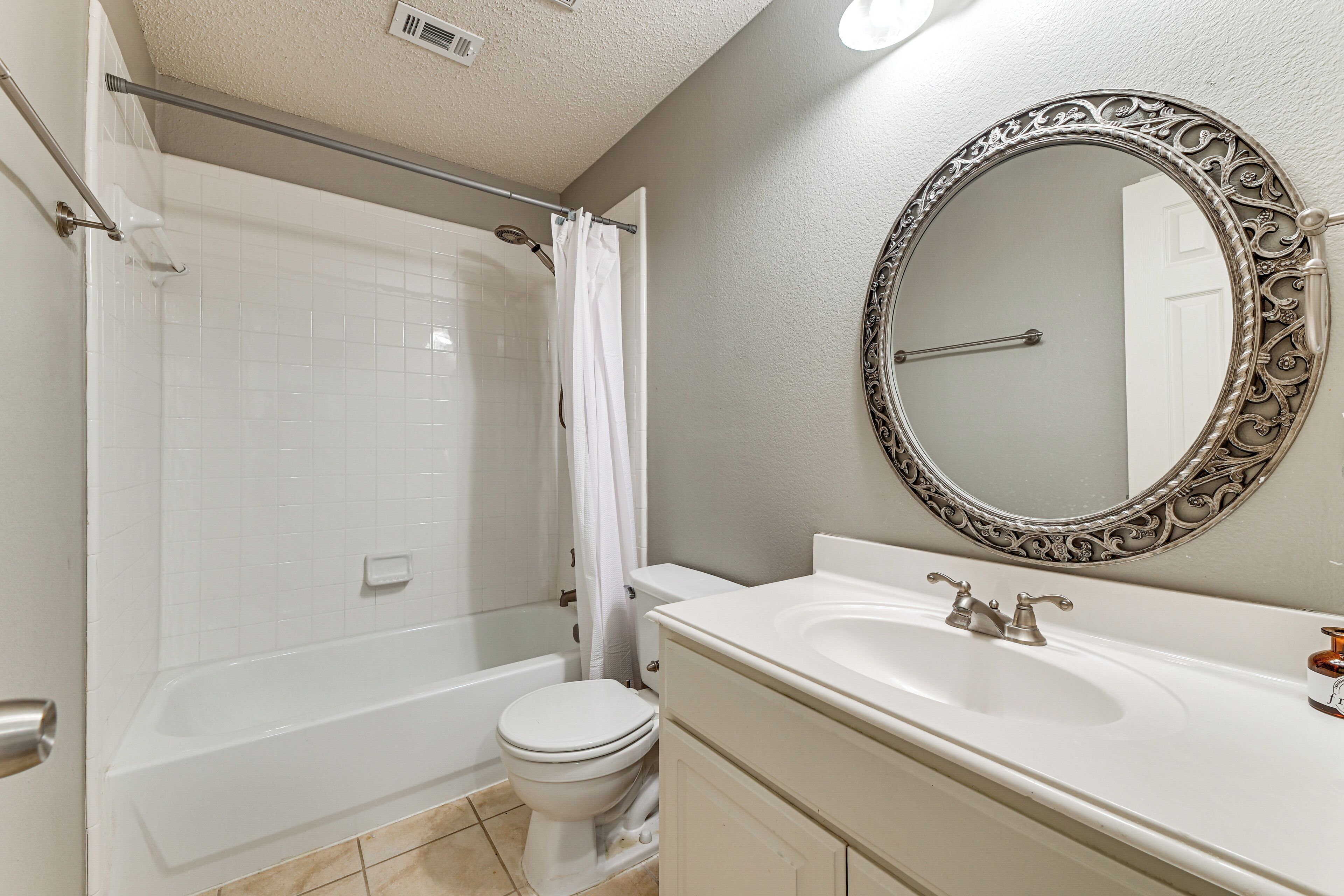 A bathroom with a bathtub, toilet, and sink.