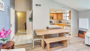 Una cocina moderna con armarios de madera, una isla central y un comedor con un banco.