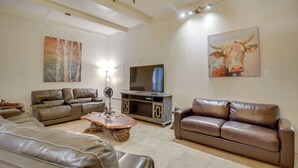 A living room with a sectional sofa, a coffee table, and a television. - Private 3-acre Retreat w/ Game Room in Bunnell! (Bunnell)