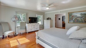 A bedroom with a bed, a television, a chair, a dresser, and a painting on the wall. - Private 3-acre Retreat w/ Game Room in Bunnell! (Bunnell)