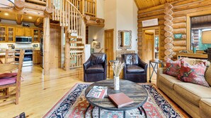 A log cabin interior with a dining area, a living room with a sofa and chairs, a staircase, and a kitchen with a microwave. - Stunning Views! Ski-in/out Mountain Village Cabin (Telluride)