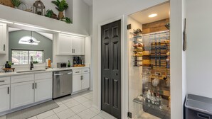 A modern kitchen with white cabinets, a dishwasher, and a glass-fronted pantry. - Disney Getaway w/ Private Hot Tub 14 Mi to Parks (Kissimmee)