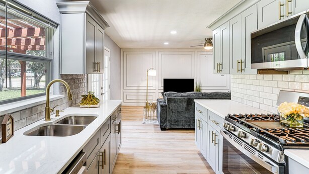 A modern kitchen with a large island, stainless steel appliances, and a view of the outdoors. - Family Home in Ft Worth Suburbs Near Benbrook Lake (Crowley)