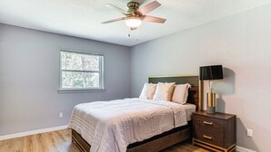 A bedroom with a bed, a nightstand, a ceiling fan, and a window. - Family Home in Ft Worth Suburbs Near Benbrook Lake (Crowley)