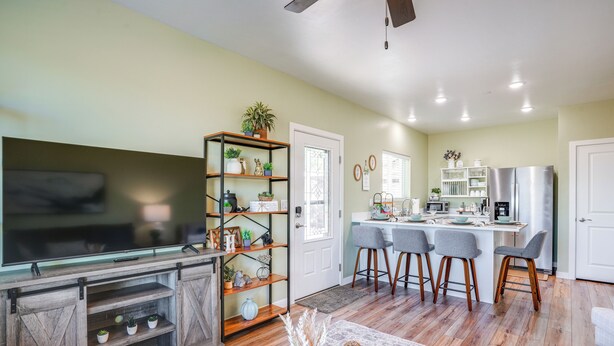 A modern kitchen with a central island, bar stools, and a built-in refrigerator.