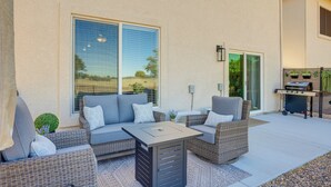 A patio with outdoor furniture, a grill, and a sliding glass door.