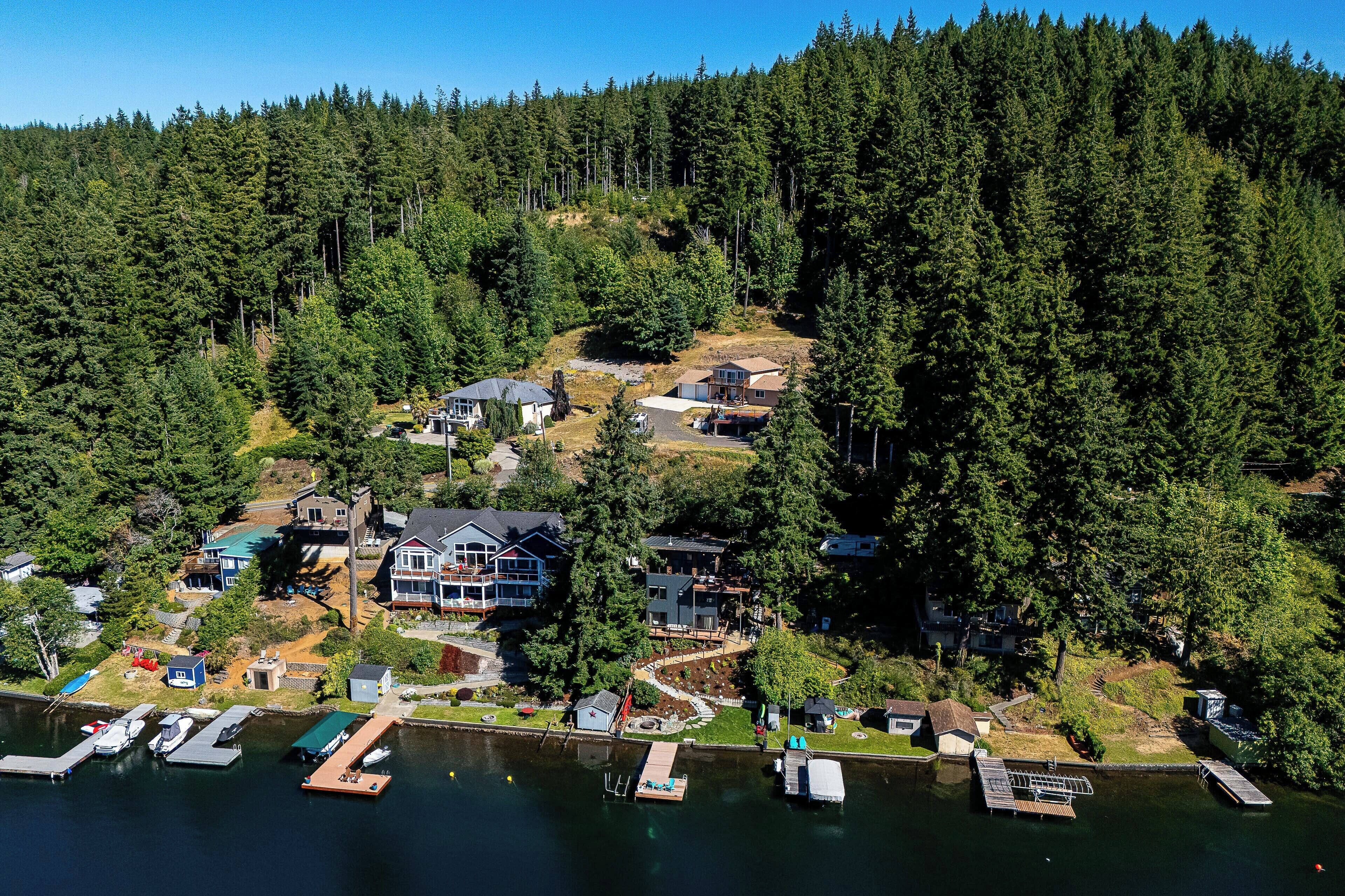Vista aérea de una zona residencial junto a un lago, con casas, muelles y barcos.