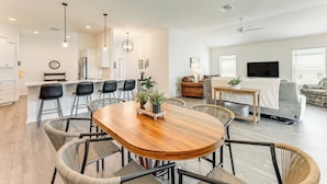 A modern living space with a dining area, kitchen, and seating area.