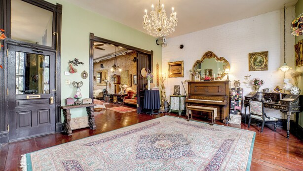 A spacious room with a large ornate rug, a grand piano, and a chandelier. - Vintage Studio in Historic Dtwn La Porte! (La Porte)