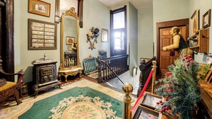 A traditional interior with a staircase, a Christmas tree, and a large mirror. - Vintage Studio in Historic Dtwn La Porte! (La Porte)