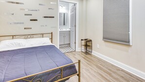 A bedroom with a bed, a bathroom visible through an open door, and a window with blinds. - 1 Mi to Dtwn Monroe: Family-friendly Duplex! (Monroe)