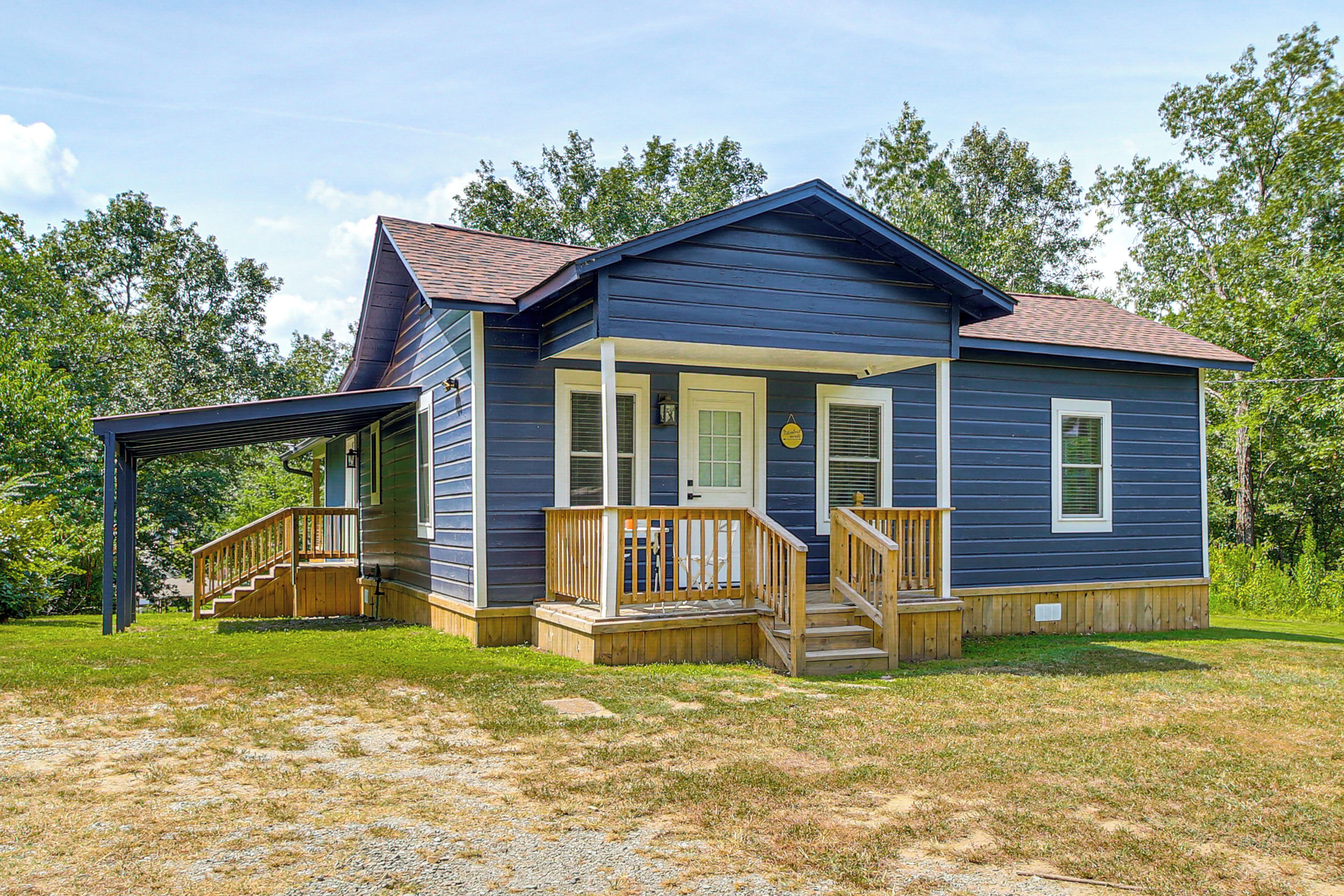 A two-story house with a covered porch and a small front yard.