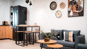 A modern kitchen with a black refrigerator, wooden cabinets, and a dining area with a table and chairs. - QH Hornillo de Cartuja (Granada)