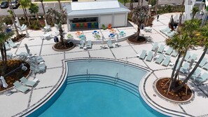 Un espace piscine avec des chaises longues et un bar.