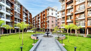 A modern apartment complex with a central courtyard, multiple balconies, and a fountain. - Luxury Garden-View 1BHK I Near Candolim Beach I Free Parking I Fast Wifi (Candolim)