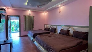 A bedroom with two beds, a ceiling fan, and a view of greenery outside. - Mountain Peak Resort  (Alur)
