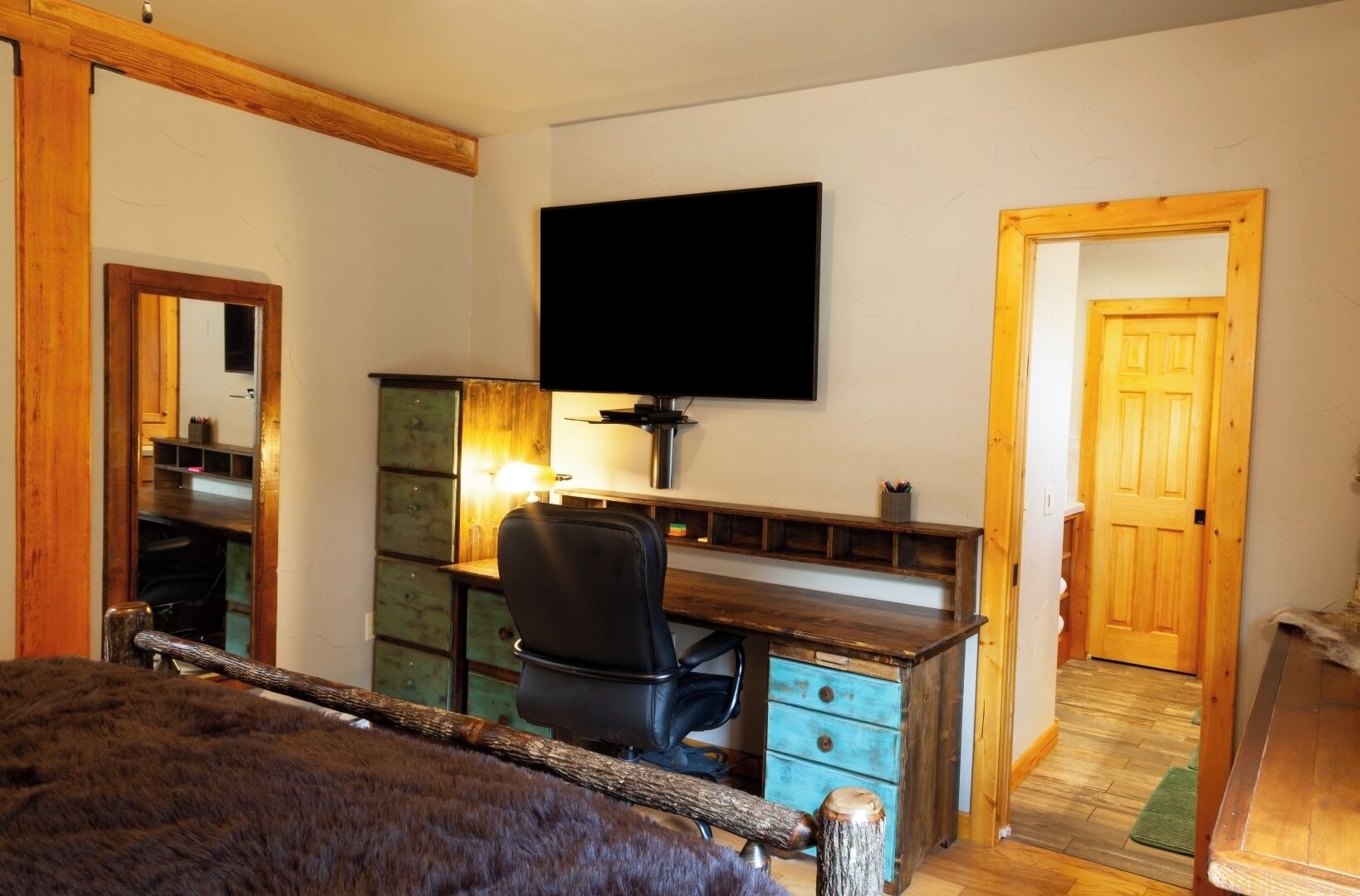 Une chambre à coucher comprenant un lit, un bureau, une chaise, une télévision et une armoire.