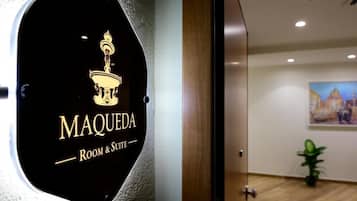 A hotel sign with the name "MAQUEDA" and the words "Room & Suite" indicating the type of accommodations offered.
