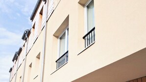 Una hilera de edificios de apartamentos modernos con balcones, ventanas amplias y fachada de madera.