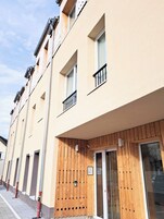 Uma fileira de edifícios de apartamentos modernos com varandas, grandes janelas e fachada de madeira.