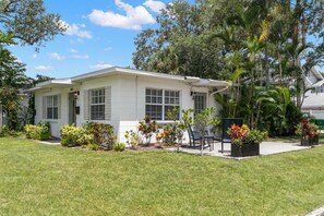 A single-story house with a white exterior, a front porch, and a well-maintained lawn.