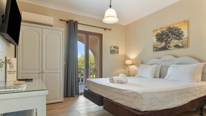 Une chambre à coucher avec un lit, un bureau, une télévision, un tableau et une vue sur l’extérieur, visible à travers une porte.