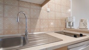 A kitchen with a stainless steel sink, a built-in stove, and a coffee maker. - Studio Apartment 'Standard  with Sea View 1' with Sea View, Wi-Fi and Air Conditioning (Vasilikos)